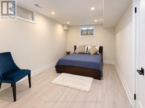 A bedroom with a bed, chair, and rug.