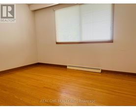 A room with wooden flooring and a window with blinds.