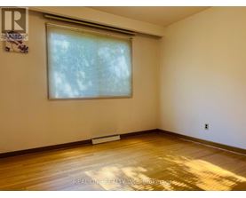 A room with a window and wooden floor.