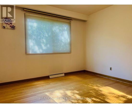 A room with a window and wooden floor.