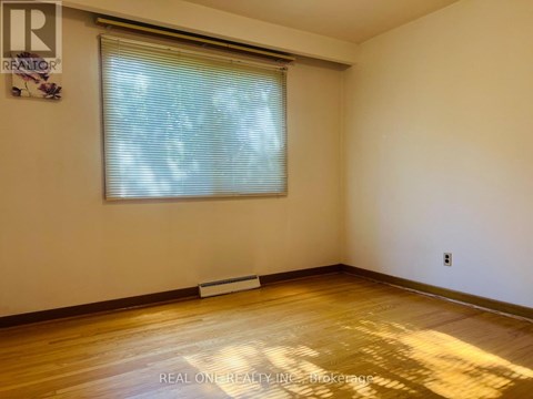A room with a window and wooden floor.