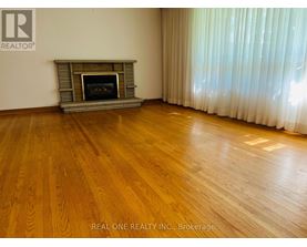 A room with a fireplace and wooden floors.