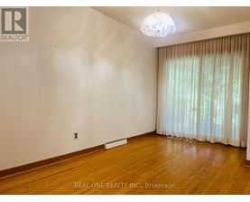 A room with wooden floors and a window with curtains.