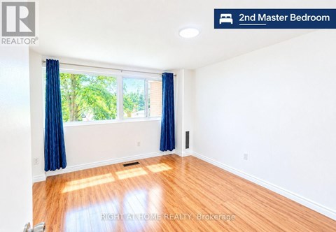 A bedroom with a window and blue curtains.