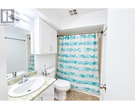 A bathroom with a sink, toilet and shower curtain.