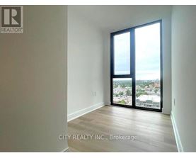 A room with a view of the city through large windows.