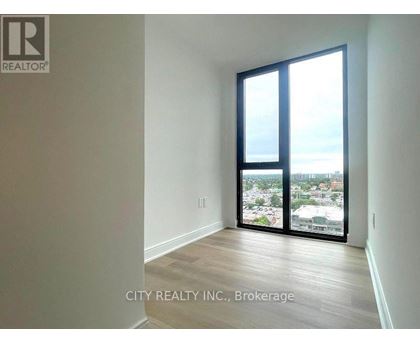 A room with a view of the city through large windows.
