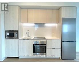 A kitchen with a sink, stove, and refrigerator.