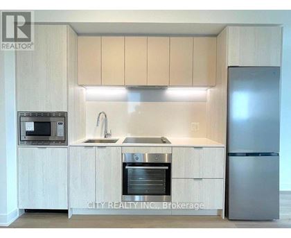 A kitchen with a sink, stove, and refrigerator.
