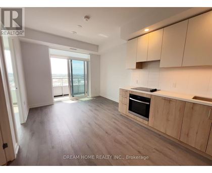 A spacious kitchen with wooden cabinets and a large window.