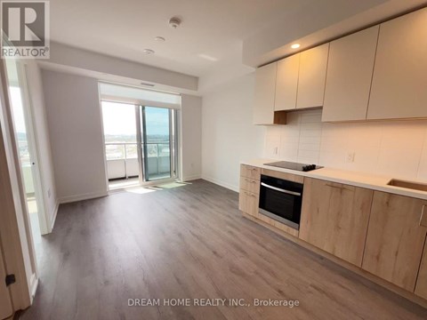 A spacious kitchen with wooden cabinets and a large window.
