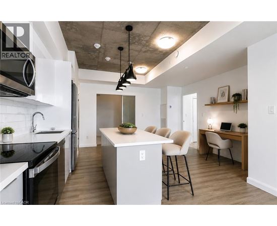 A modern kitchen with a white island and black countertops.