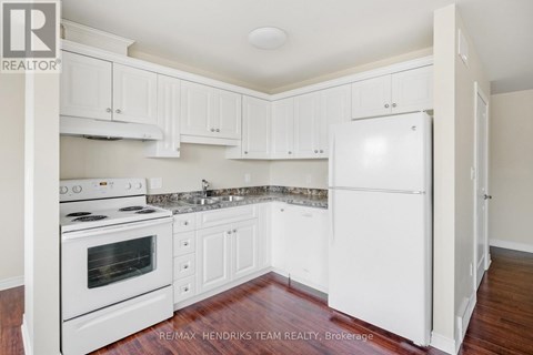 A kitchen with white cabinets and appliances.