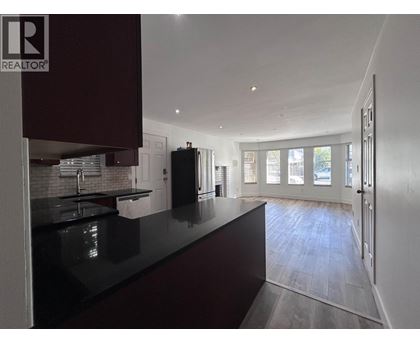 A modern kitchen with dark brown cabinets and a black countertop.