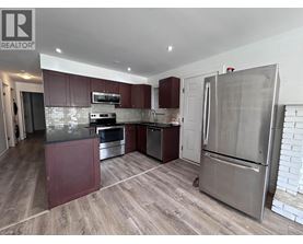 A kitchen with a refrigerator, oven, and microwave.
