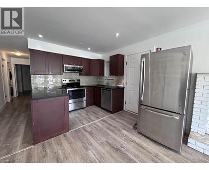 A kitchen with a refrigerator, oven, and microwave.