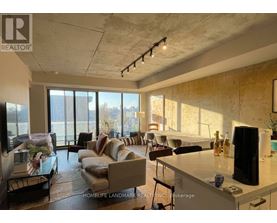 A living room with a couch, a chair, a table, and a television.