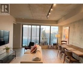 A living room with a couch, chairs, and a television.