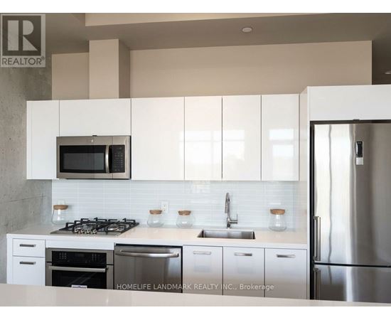 A kitchen with white cabinets and a stainless steel refrigerator.