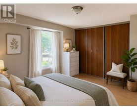 A bedroom with a bed, nightstand, and a window with curtains.