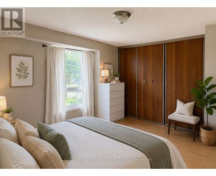 A bedroom with a bed, nightstand, and a window with curtains.