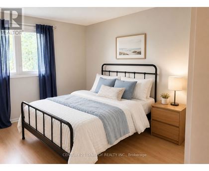 A bedroom with a bed, nightstand, and a window with blue curtains.