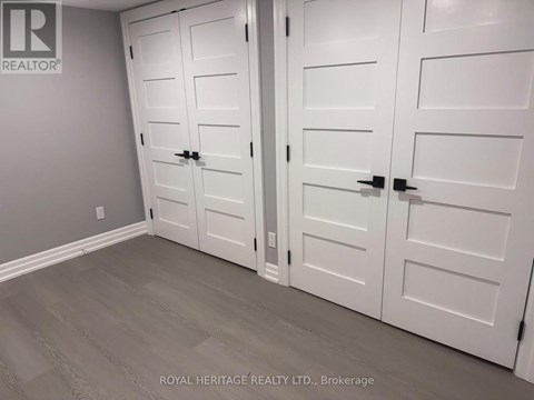 A white closet with a grey wall and a logo that says "REALTOR" on the top left.