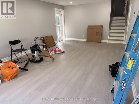 A room with a wooden floor and a ladder is shown.
