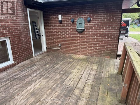 A wooden deck with a brick wall and a door.