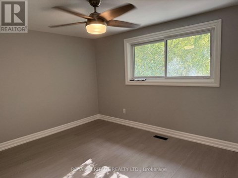 A room with a ceiling fan and a window.