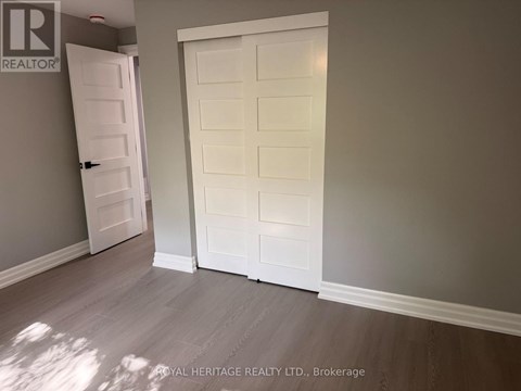 A white door is open to a room with a grey wall.