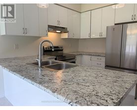 A kitchen with a granite countertop and stainless steel appliances.