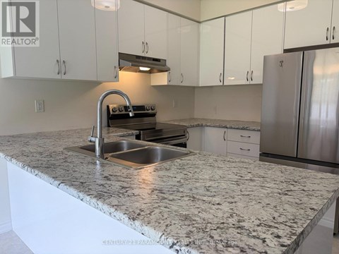 A kitchen with a granite countertop and stainless steel appliances.