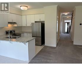 A kitchen with white cabinets and a granite countertop.