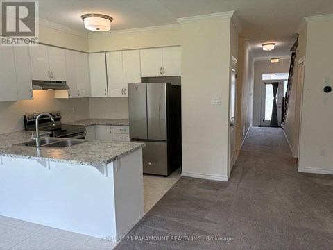 A kitchen with white cabinets and a granite countertop.