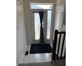A hallway with a door leading outside.