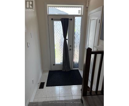 A hallway with a door leading outside.