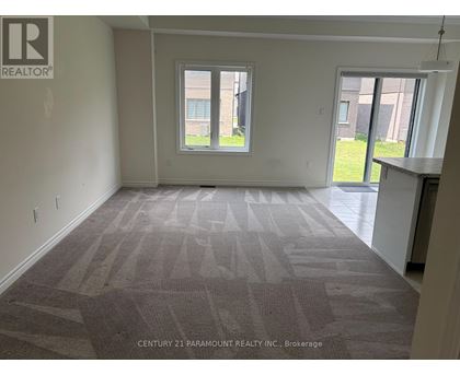 A room with a carpeted floor and a window letting in light.