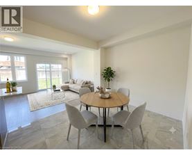 A dining room with a round table and grey chairs.