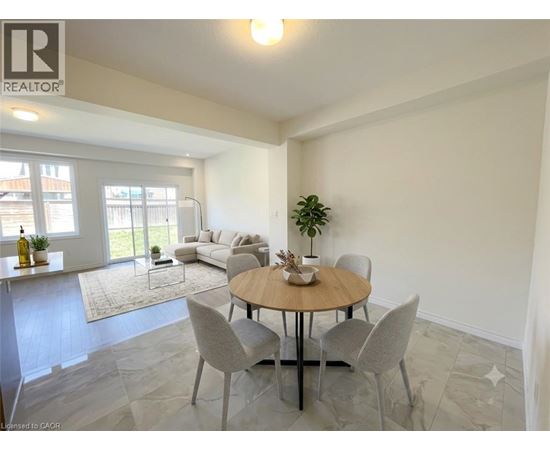 A dining room with a round table and grey chairs.