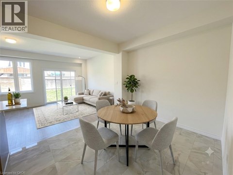 A dining room with a round table and grey chairs.
