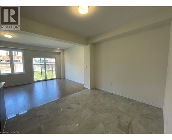A spacious room with a slanted ceiling and a large window.