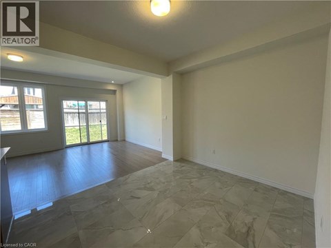 A spacious room with a slanted ceiling and a large window.