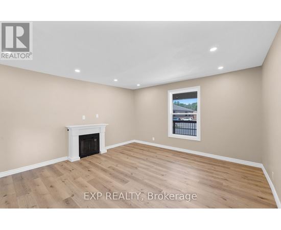 A room with a fireplace and a window overlooking a balcony.