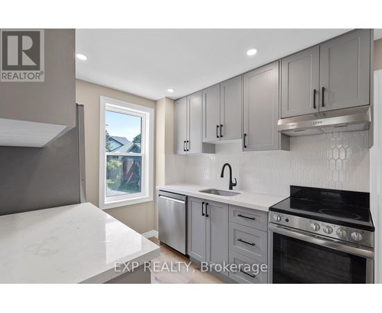 A modern kitchen with a stove top oven and a window.