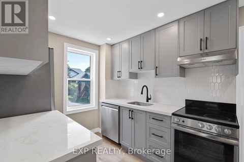 A modern kitchen with a stove top oven and a window.