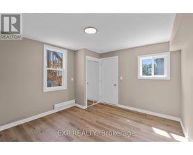 A room with a white door and a window with a view of trees.