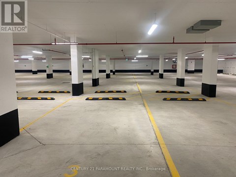 A spacious parking garage with multiple parking spaces and yellow lines on the floor.