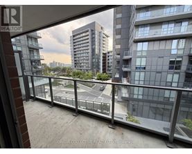 A balcony view of a cityscape with buildings and a road.