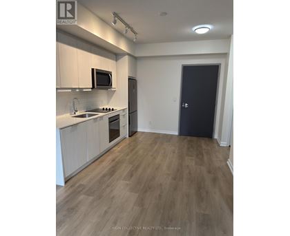 A kitchen with wooden floors and white cabinets.